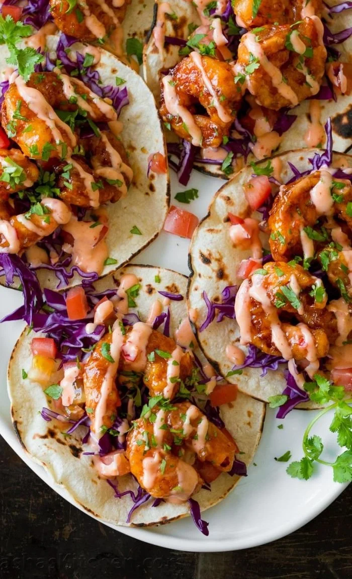 Delicious Bang Bang Shrimp Tacos served on a plate with fresh ingredients