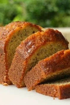 Slice of delicious moist banana bread on a wooden cutting board