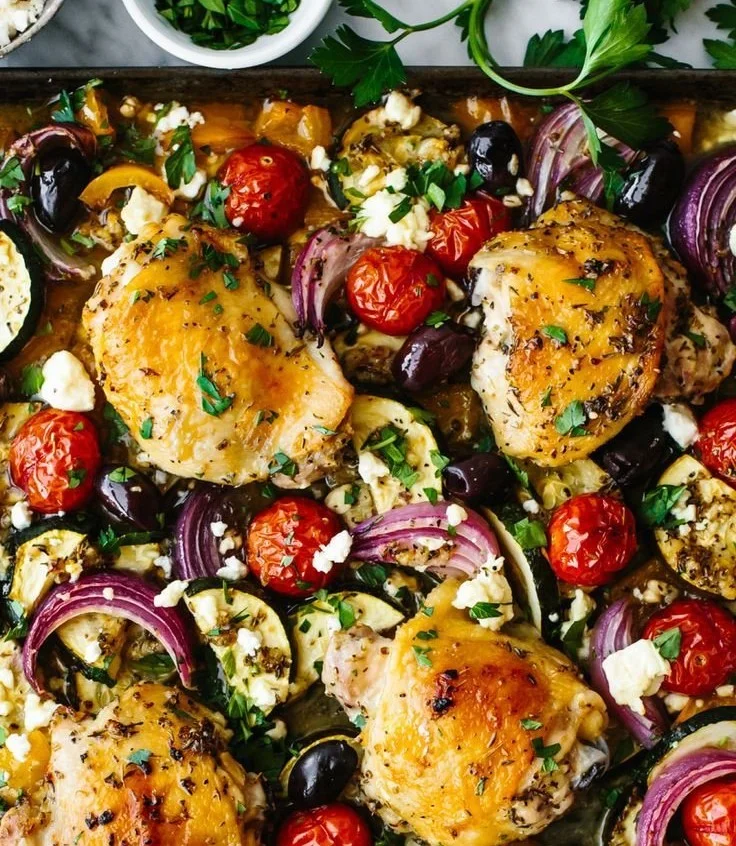 Greek-style sheet pan chicken with vegetables served on a baking tray