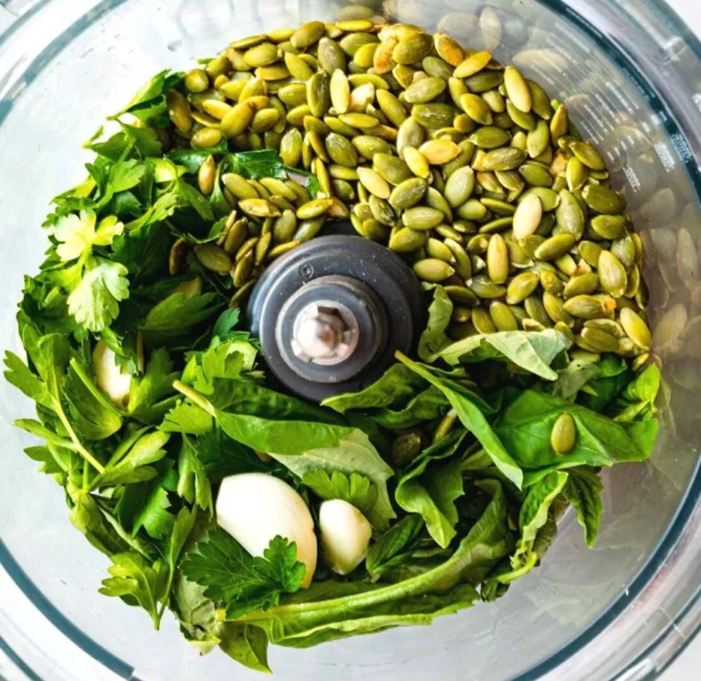 Nut-free pumpkin seed pesto in a bowl with basil and garlic.
