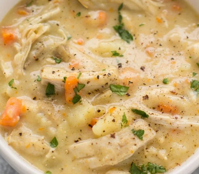 A bowl of protein-packed chicken pot pie soup topped with fresh herbs.