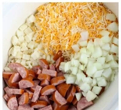 Slow cooker sausage potato casserole topped with cheese and herbs
