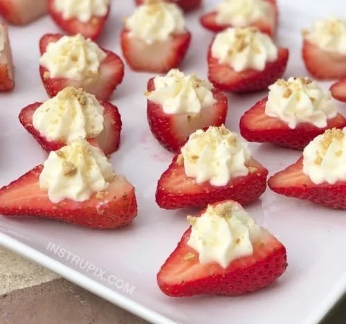 Strawberry party snacks with creamy cheese filling on a platter.