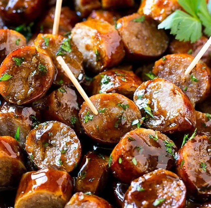 Plate of flavorful beer brat bites served with dipping sauce