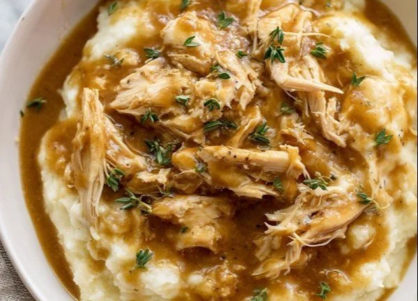 Plate of chicken with gravy and mashed potatoes, delicious home-cooked meal.