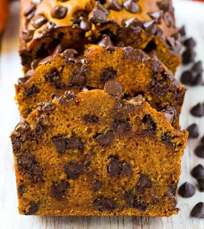Loaf of chocolate chip pumpkin bread on a wooden cutting board