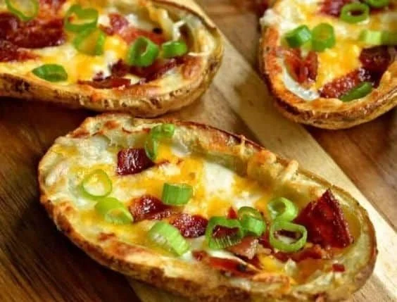 Crispy baked potato skins with bacon and green onions on a serving platter
