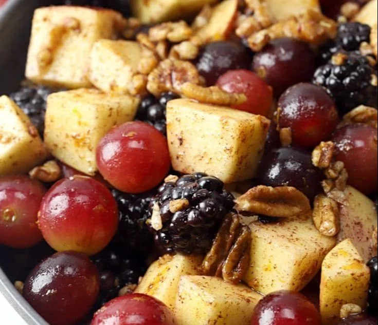 Vibrant fall fruit salad topped with cinnamon orange dressing