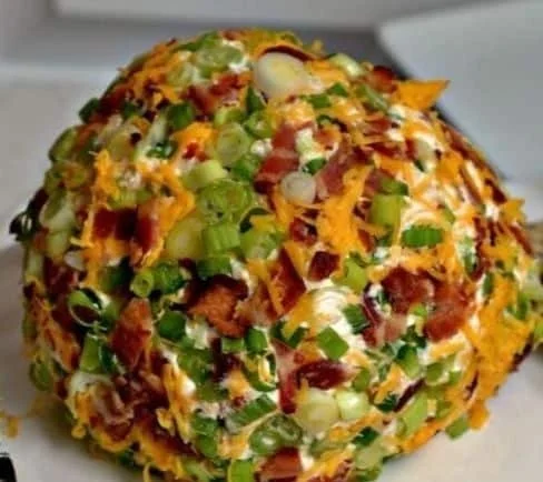 Jalapeno popper cheese ball served with crackers at a game day party