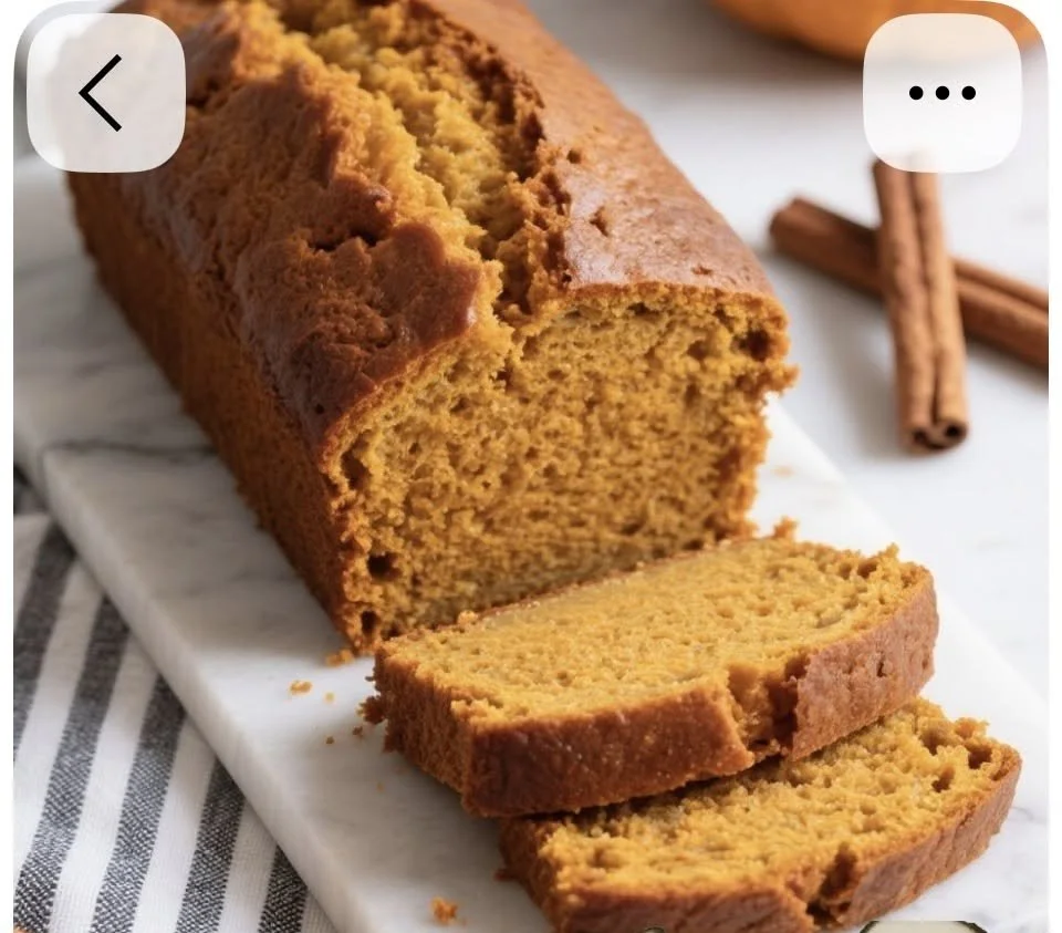 Slice of nut-free pumpkin bread with spices and pumpkin seeds on a wooden table