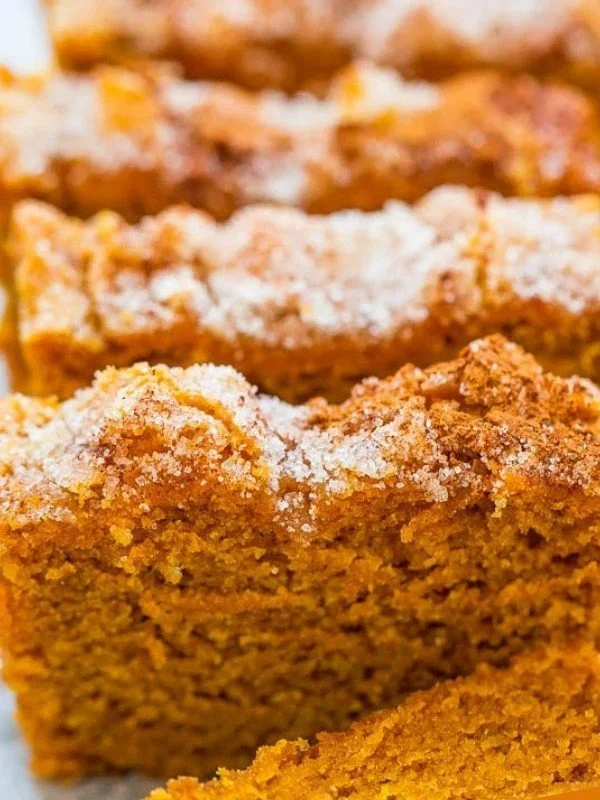 Delicious slices of pumpkin bread topped with cinnamon sugar and served on a plate