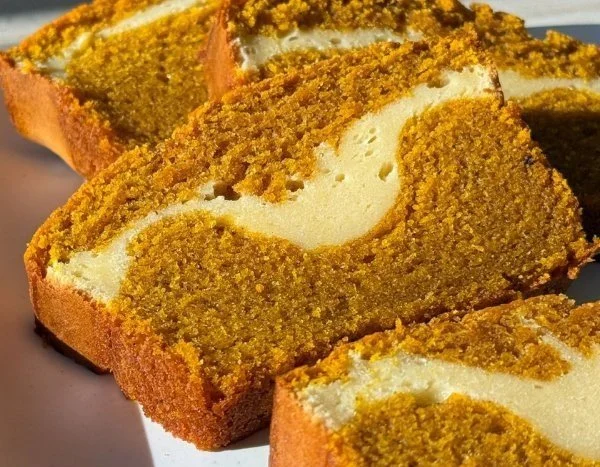 Slice of pumpkin cheesecake bread topped with cream cheese frosting