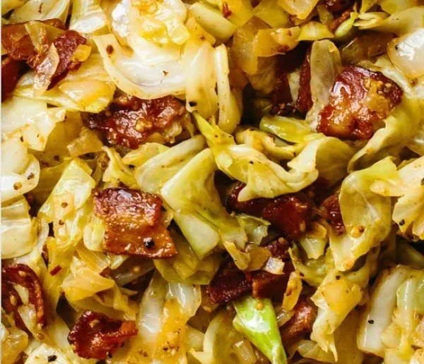 Delicious Southern fried cabbage in a skillet, garnished with herbs.